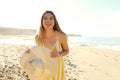 Happy cheerful girl in summer dress holding straw hat on tropical beach. Portrait of happy young woman smiling at sea on Costa Royalty Free Stock Photo