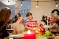 Happy and Cheerful group of extended Asian family. Granddaughter talking and smiling with grandparent during Christmas dinner.