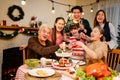 Happy and Cheerful group of extended Asian family has a toast and cheer during Christmas dinner at home. Celebration holiday Royalty Free Stock Photo