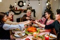Happy and Cheerful group of extended Asian family has a toast and cheer during Christmas dinner at home. Celebration holiday Royalty Free Stock Photo