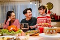 Happy and Cheerful group of extended Asian family talking and smiling during Christmas dinner at home. Celebration holiday