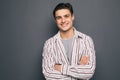 Happy cheerful guy with crossed hands on gray background Royalty Free Stock Photo