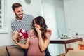 Happy cheerful husband giving present box to his pregnant wife Royalty Free Stock Photo