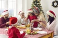 Happy grandma and granddaughter cutting turkey at Christmas holiday meal at home