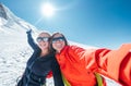 Happy cheerful laughing embracing young female selfie portrait while they descending after a successful mountain top climbing.