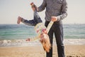 Happy cheerful loving family, father and little daughter playing on beach, young father is holding his kid upside down Royalty Free Stock Photo