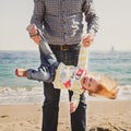 Happy cheerful loving family, father and little daughter playing on beach, young father is holging his kid upside down Royalty Free Stock Photo