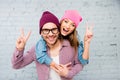 Happy cheerful man and woman embracing and gesturing with two fingers