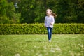 Happy cheerful preschool girl walking in park