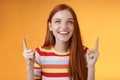 Happy cheerful redhead girl having fun amusement park laughing joyfully pointing look up index fingers upwards enjoy Royalty Free Stock Photo