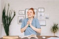 Happy cheerful redhead young woman is hold smartphone laughing watching funny video online, Royalty Free Stock Photo