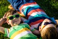 Happy cheerful smiling children, laying on a grass, wearing sung Royalty Free Stock Photo