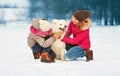 Happy cheerful smiling family playing having fun together in winter day, mother and child walking with white Samoyed dog in snowy Royalty Free Stock Photo