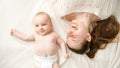 Happy cheerful smiling and laughing baby boy with mother lying on bed. Concept of parenting ,baby hygiene and child Royalty Free Stock Photo
