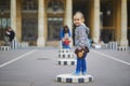 Happy cheerful toddler girl running within Columns of Buren in Palais-Royale, Paris Royalty Free Stock Photo