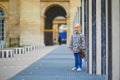 Happy cheerful toddler girl running within Columns of Buren in Palais-Royale, Paris Royalty Free Stock Photo