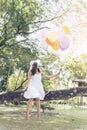 Happy cheerful woman holding colorful of balloons wear sunglasses on green meadow with cloudy blue sky. Royalty Free Stock Photo