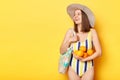 Happy cheerful woman wearing swimsuit isolated on yellow background standing with fresh oranges looking away at advertisement area Royalty Free Stock Photo