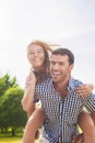 Happy and Cheerful Young Caucasian Couple Piggybacking Outdoors. Royalty Free Stock Photo