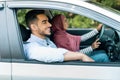 Happy cheerful young muslim woman in hijab is driving car, husband enjoying journey with open window Royalty Free Stock Photo