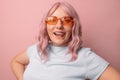 Happy cheerful young 30s woman blogger in bright orange stylish glasses shows his tongue and beautiful white teeth Royalty Free Stock Photo