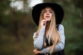 Happy cheerful young woman in black hat outdoor. Joyful attractive girl in park. Royalty Free Stock Photo