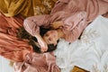 Charming young woman in pink dress lying on floor over composition of dresses Royalty Free Stock Photo