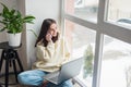 Happy cheerful young woman talking on the phone at home, smiling teenage girl answering a call on a mobile phone. Soft selective Royalty Free Stock Photo