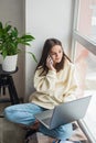 Happy cheerful young woman talking on the phone at home, smiling teenage girl answering a call on a mobile phone. Soft selective Royalty Free Stock Photo