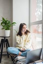 Happy cheerful young woman talking on the phone at home, smiling teenage girl answering a call on a mobile phone. Soft selective Royalty Free Stock Photo