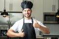 Happy chef cook with thumb up. Man in chef hat cooking on kitchen. Royalty Free Stock Photo
