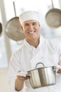 Happy Chef Holding Utensil In Commercial Kitchen