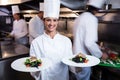 Happy chef presenting her food plates Royalty Free Stock Photo