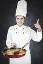 Happy chef shows thumb up and tasty food Royalty Free Stock Photo