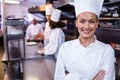 Happy chef standing in commercial kitchen in a restaurant