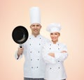 Happy chefs or cooks couple with frying pan