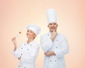 Happy chefs or cooks couple over beige background