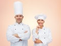 Happy chefs or cooks couple over beige background