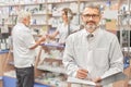 Happy chemist smiling, posing in pharmacy.