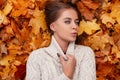 Happy chic pretty young woman with blue eyes with brown hair in a knitted fashionable sweater is resting lying on the orange