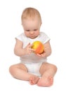 Happy child baby boy sitting in diaper and eating red yellow app Royalty Free Stock Photo