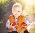 Happy child (baby boy) with two red organic apples in the autumn (fall) day. Kid eating healthy food, snack. Royalty Free Stock Photo