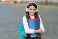 Happy child back to school carry books listening music, modern teenager concept