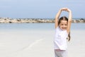 Happy child on the beach. Paradise holiday concept, girl seating on sandy beach with blue shallow water and clean sky Royalty Free Stock Photo