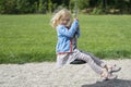 Happy Child blond girl (age 5) rids on Flying Fox play equipment in a children's playground.