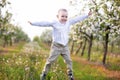 A happy child in a blooming spring garden plays