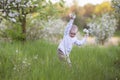 A happy child in a blooming spring garden plays