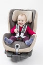 Happy child in booster seat for a car in light background