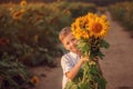 Happy child with bouquet of beautiful sunflowers in summer sunflower field on sunset. Mother day Royalty Free Stock Photo