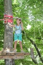 Happy child boy in adventure park in safety equipment Royalty Free Stock Photo